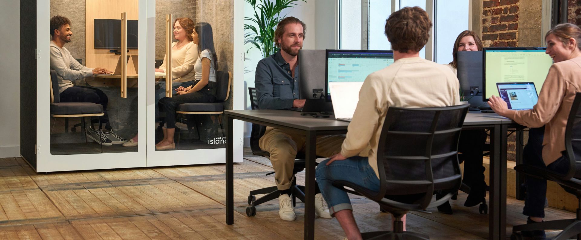Businessman and businesswoman collaborating with laptops in an outdoor urban setting.